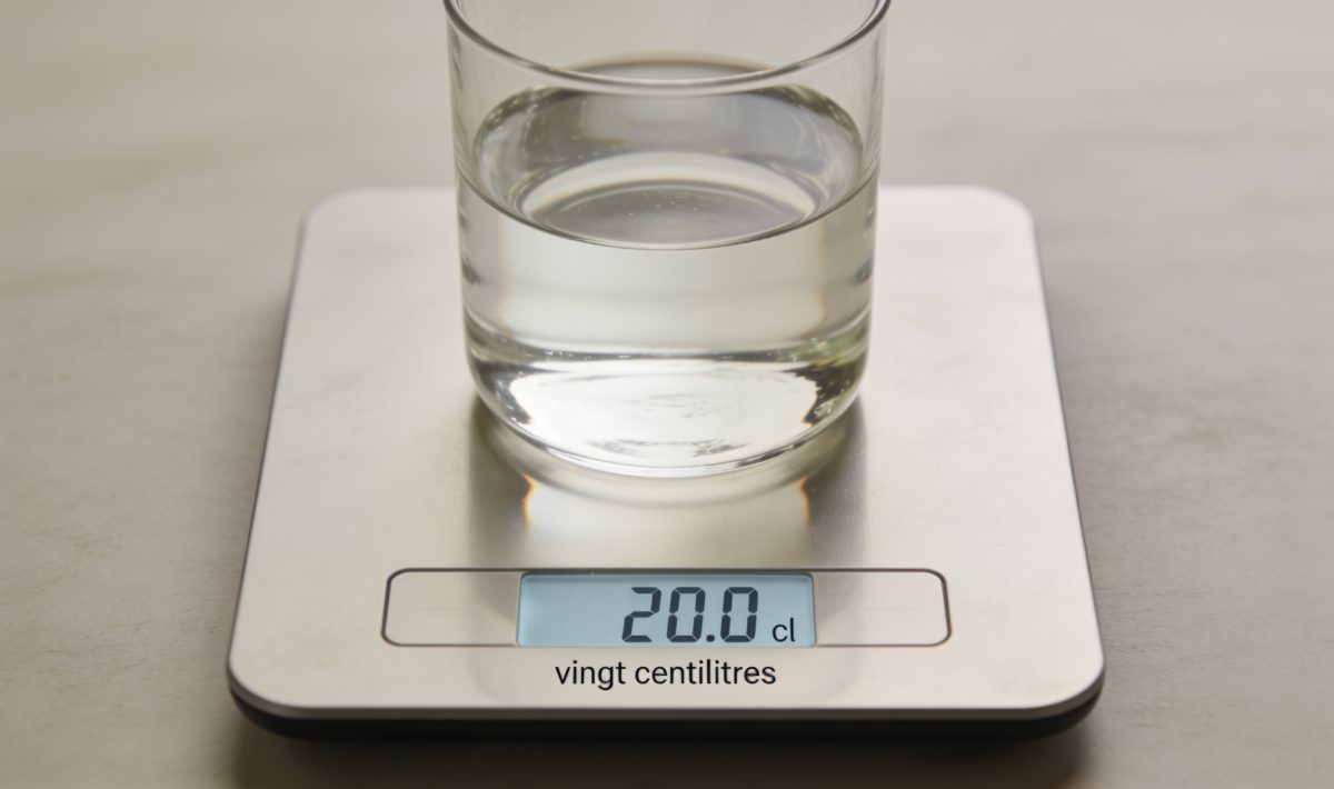 Balance de cuisine affichant vingt centilitres de liquide clair.