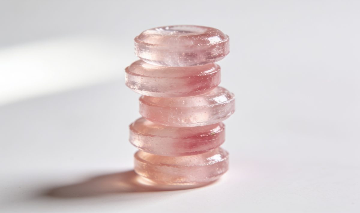 Bonbons roses translucides empilés sur surface blanche