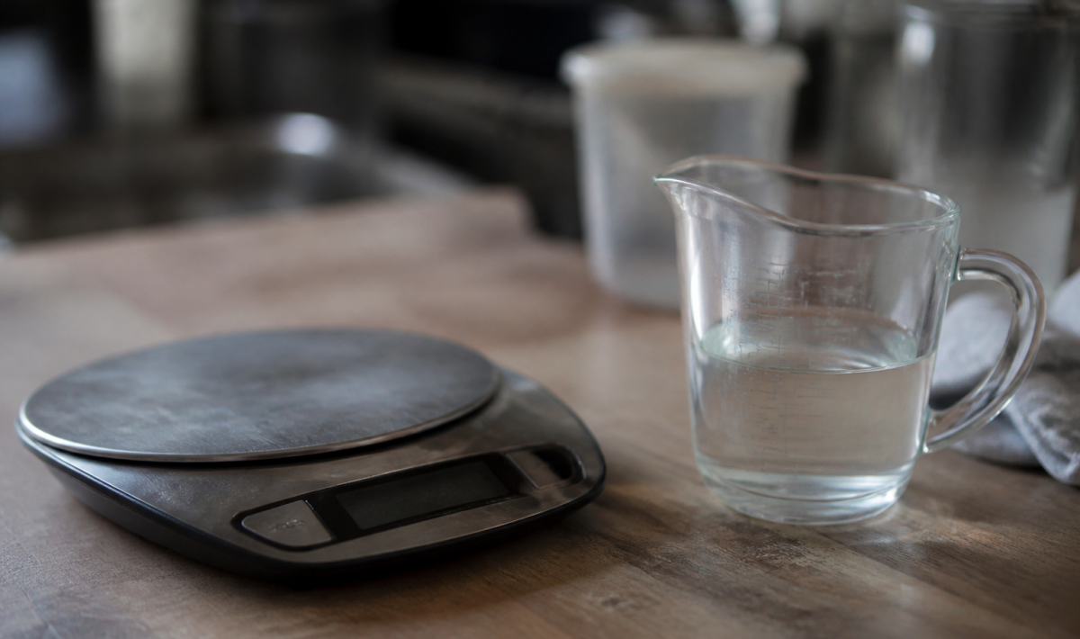 Verre mesure avec liquide pres d'une balance numerique.