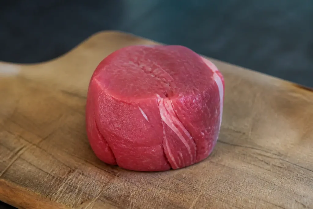 Filet mignon rose posé sur planche en bois