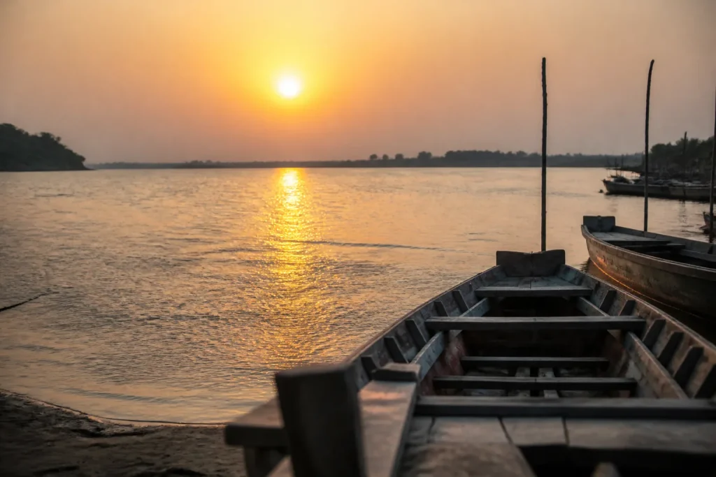Fleuve large au soleil couchant, barques en bois
