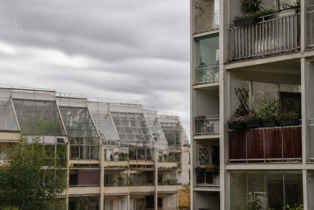 Immeubles collectifs serres, balcons fleuris, ciel gris
