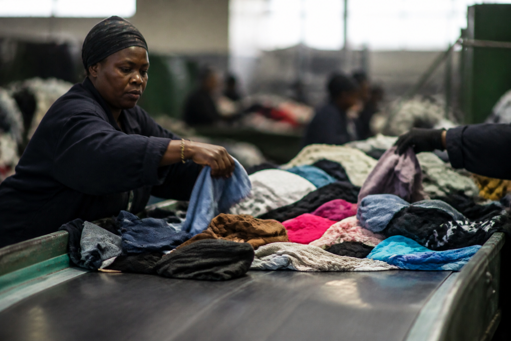 Operateurs triant des textiles colores sur un tapis roulant